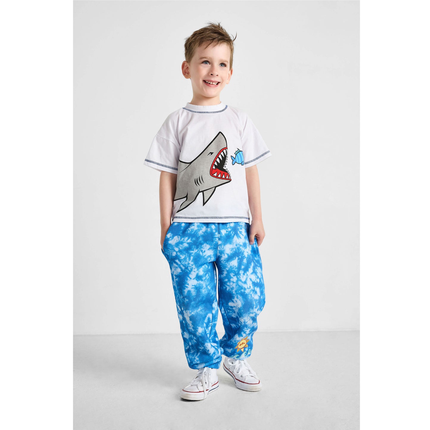 Smiling boy wearing our sustainable Ocean Tie-Dye Joggers and Shark Crewneck T-Shirt