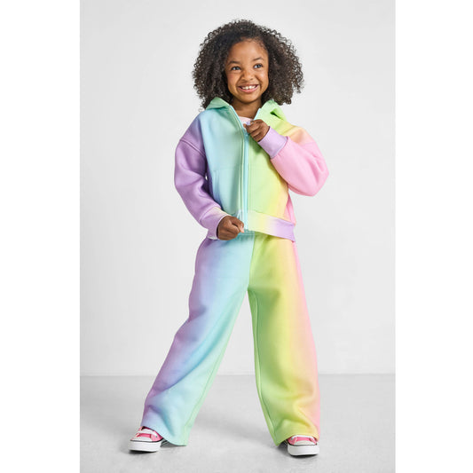 girl wearing our sustainable rainbow wide-leg jogger set and zipping up rainbow zip-up hoodie