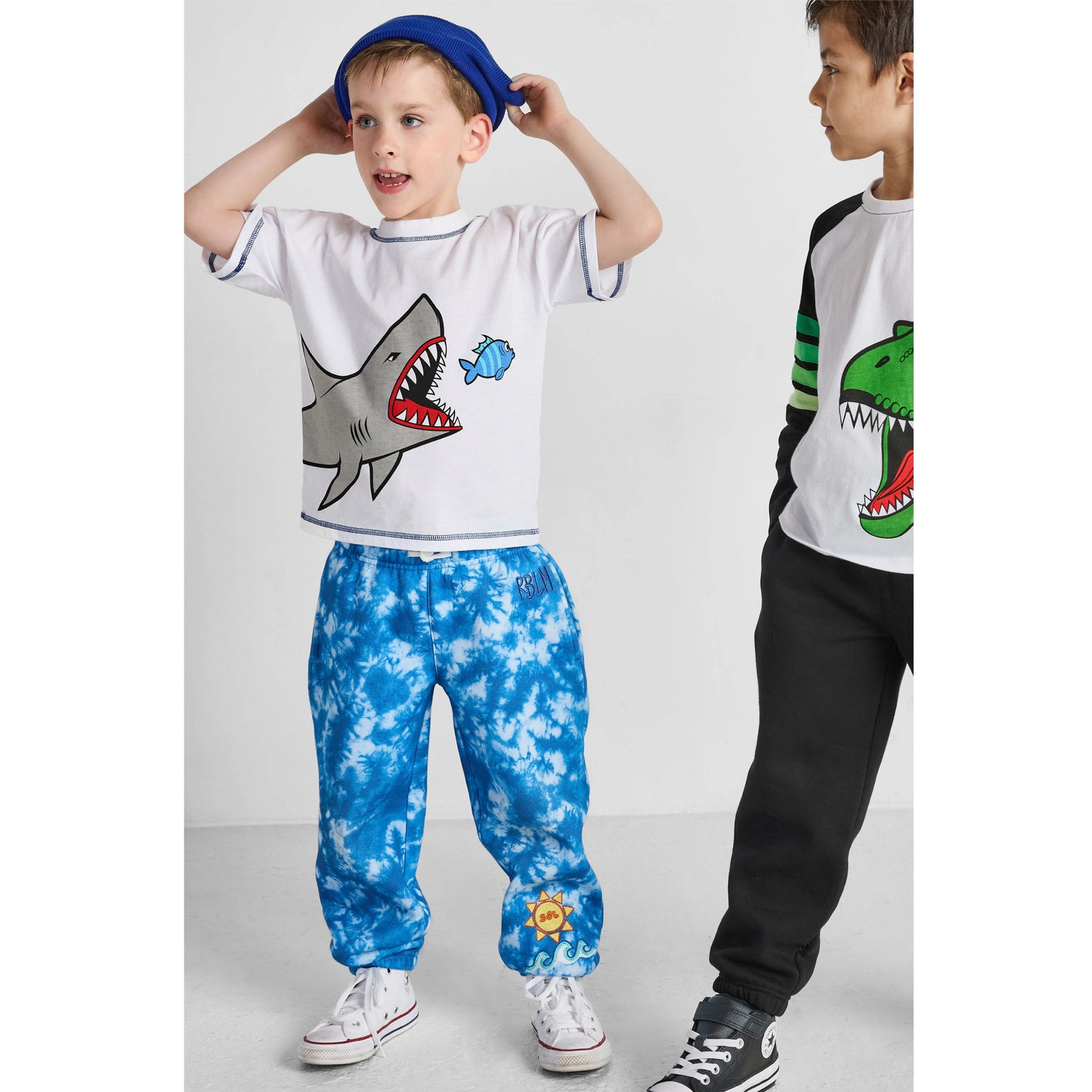 boy wearing our sustainable shark tee and blue tie-dye ocean pants