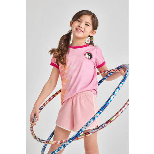 Girl in a sustainable, pink summer outfit with a hula hoop