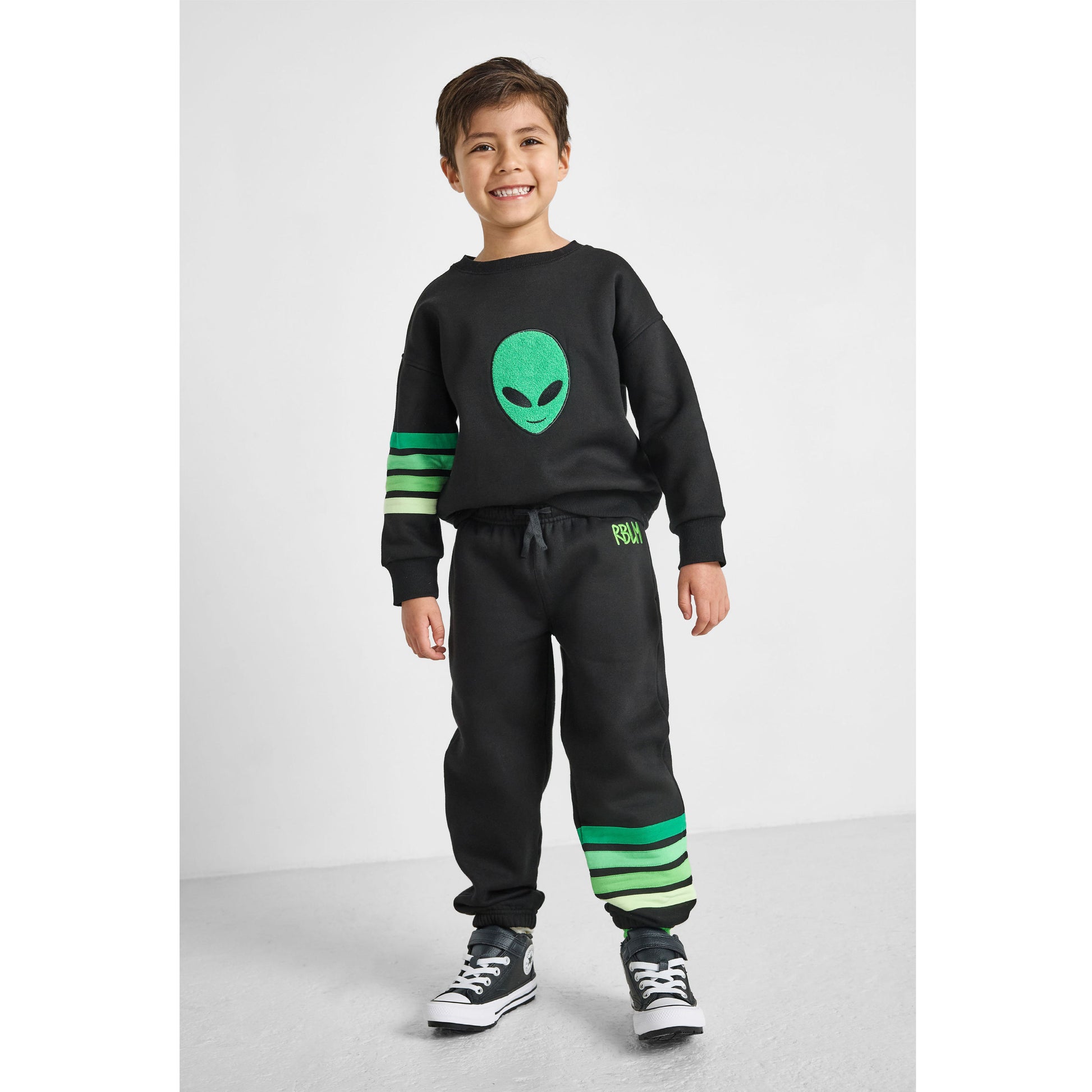 boy wearing our eco-friendly alien sweatshirt and matching green striped joggers