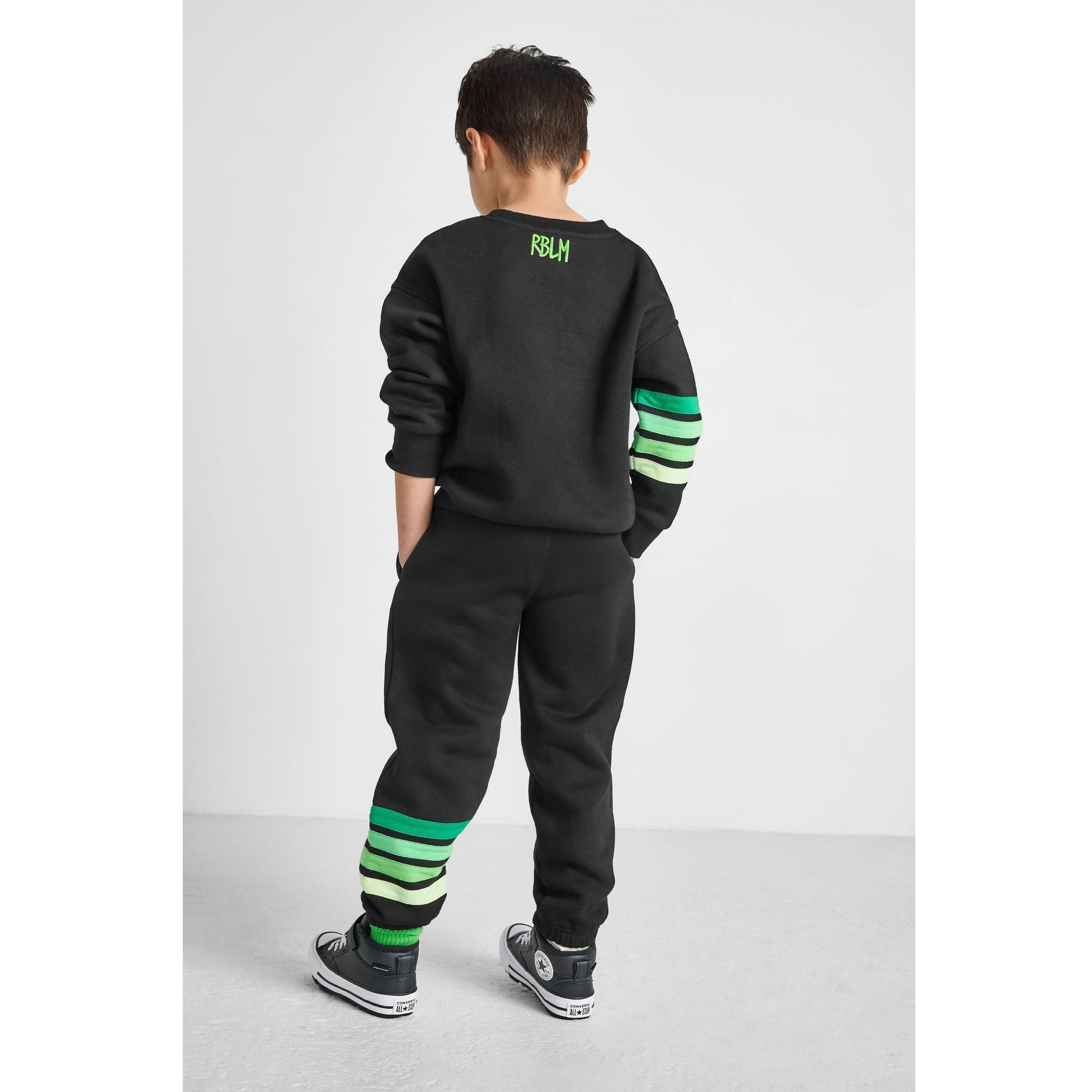back view of boy wearing our eco-friendly alien sweatshirt and green striped joggers