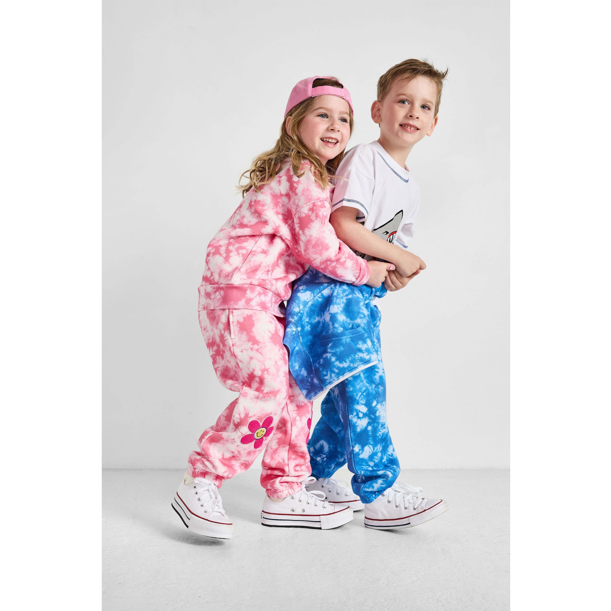 hugging children wearing our sustainable Smiley and Shark Tie-Dye Sets