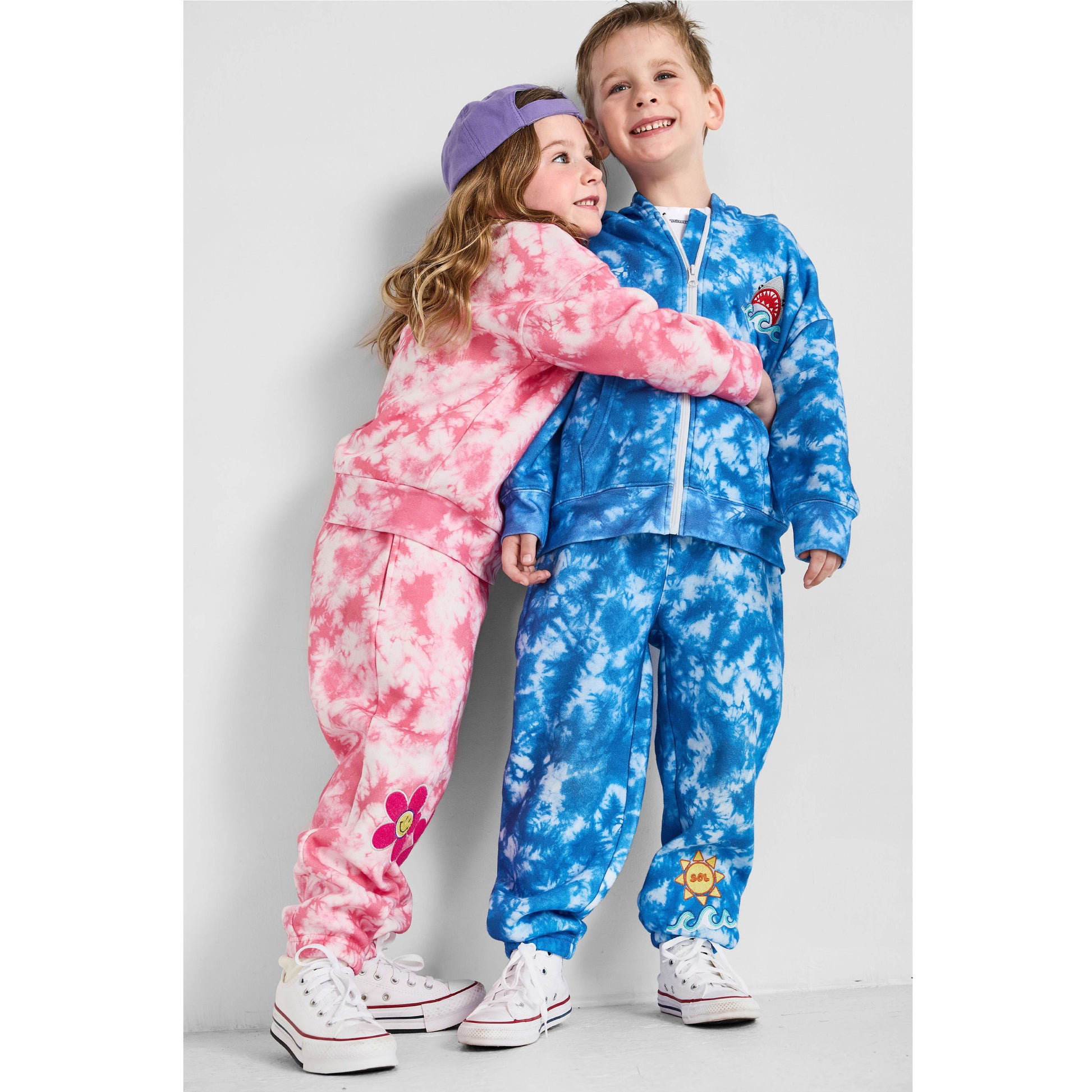 Kids hugging wearing our sustainable Smiley Tie-Dye and Shark Tie-Dye Sets