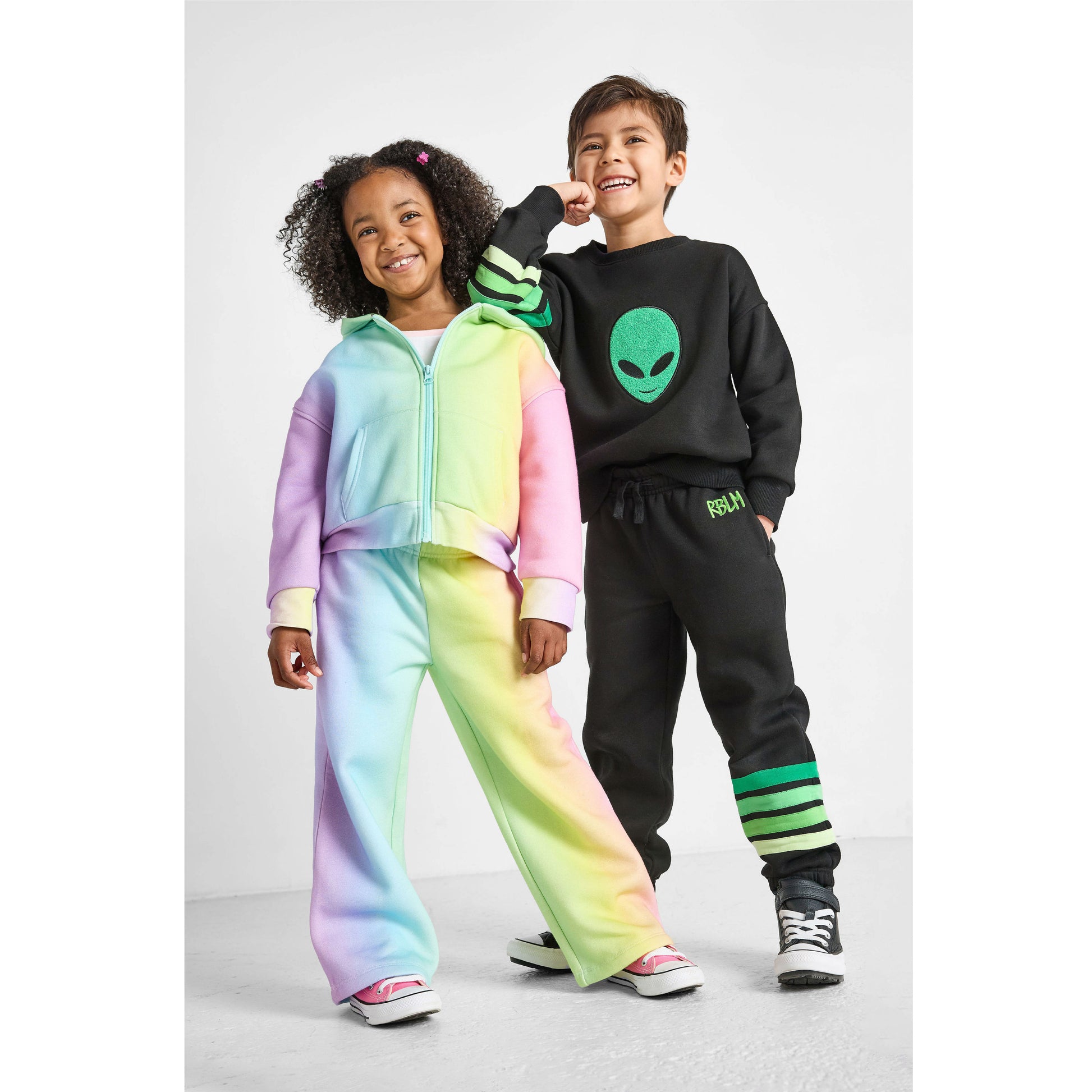girl wearing our eco-friendly rainbow set and boy wearing our alien set