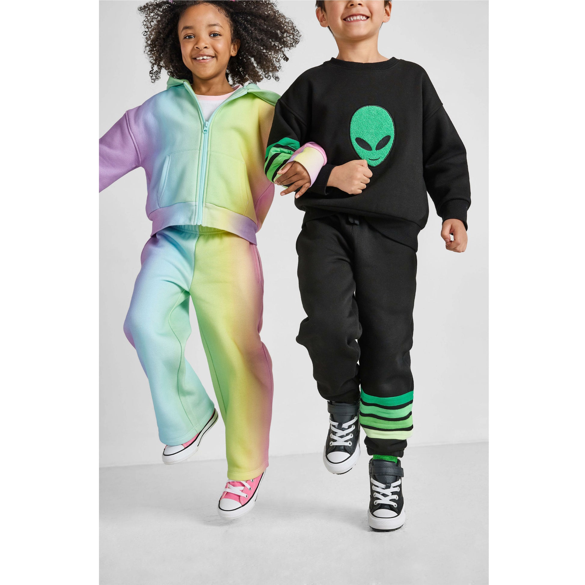 girl and boy skipping, wearing our eco-friendly rainbow and alien sets