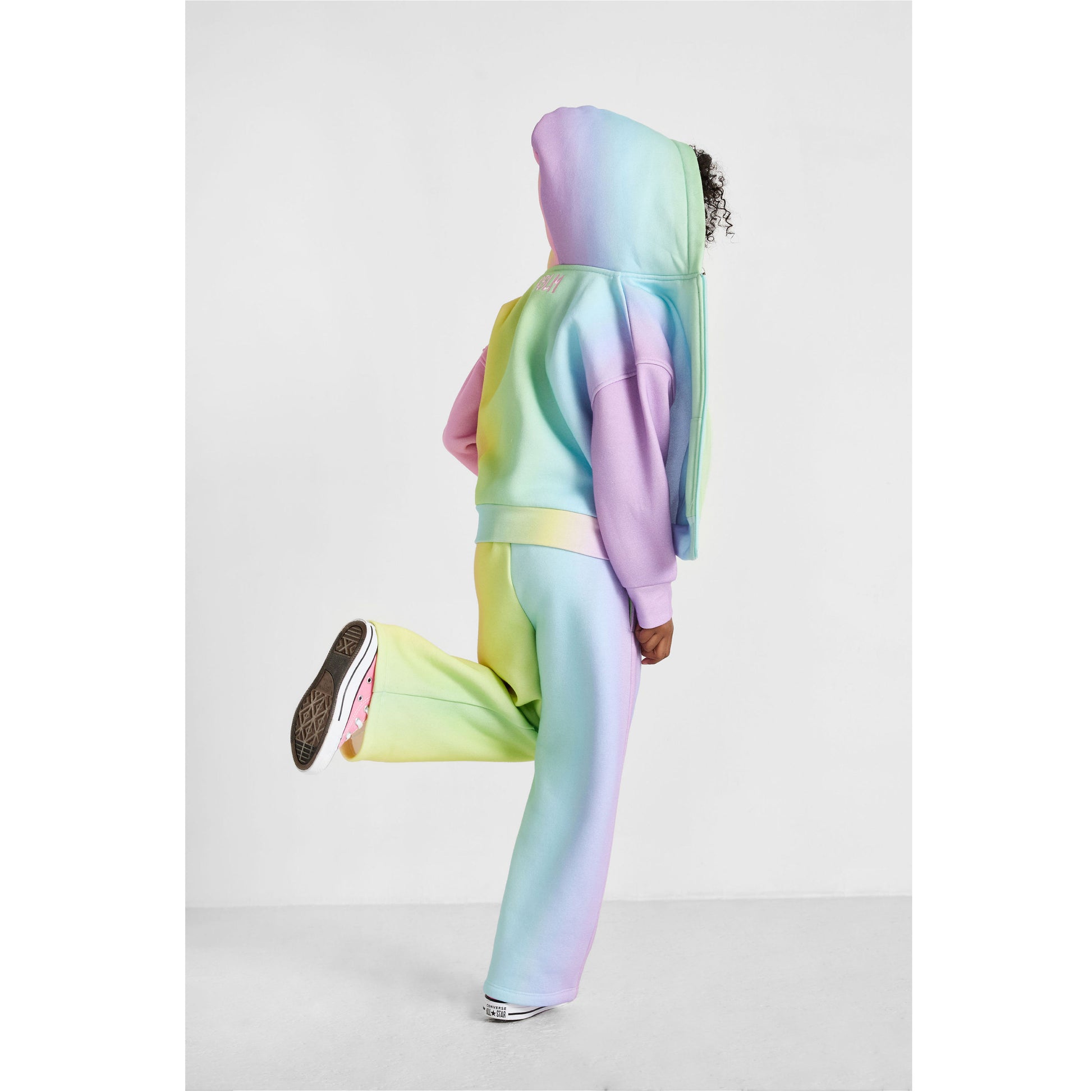 girl wearing our sustainable rainbow wide-leg jogger set, showing back of outfit