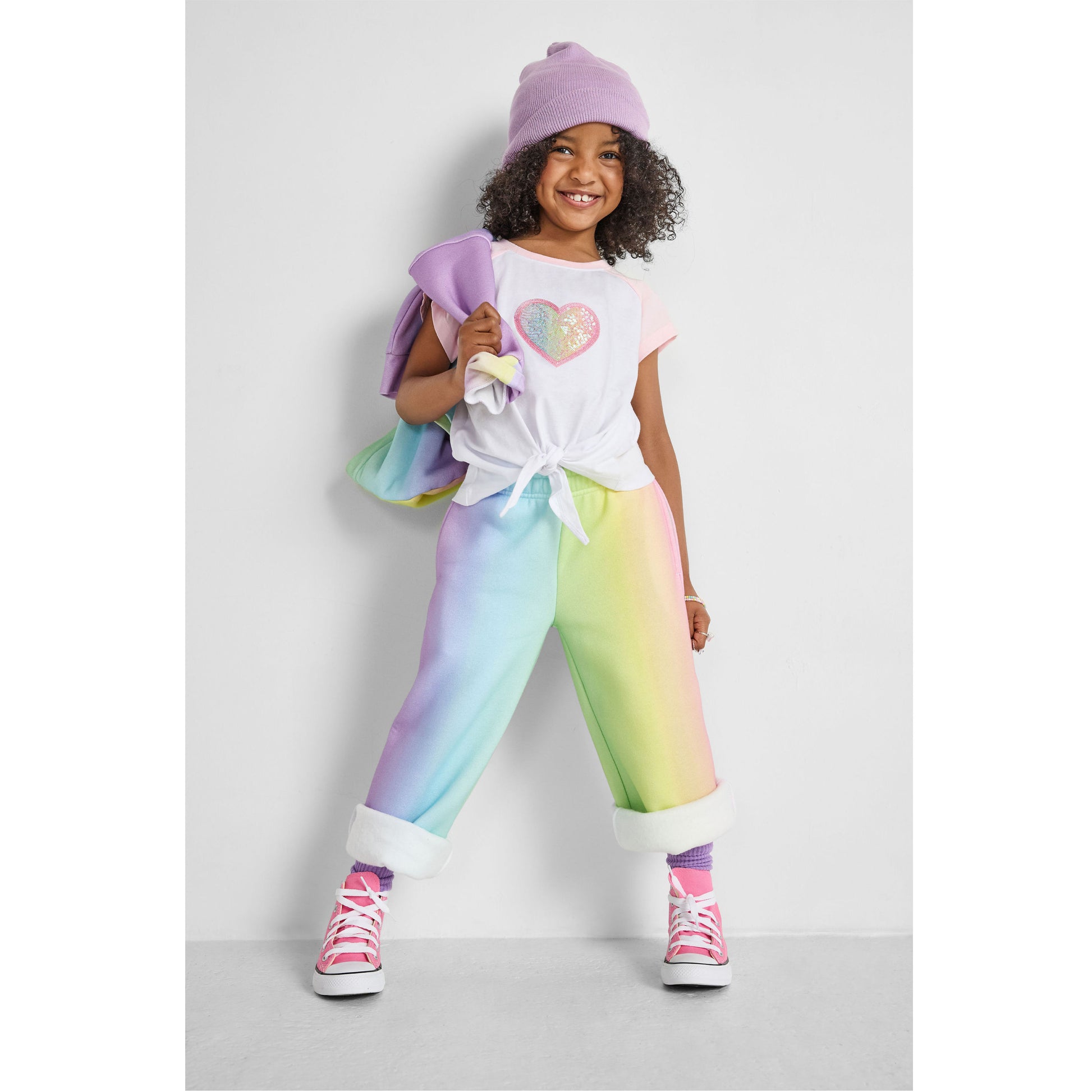girl wearing our sustainable heart knotted baseball tee with rainbow wide-leg joggers