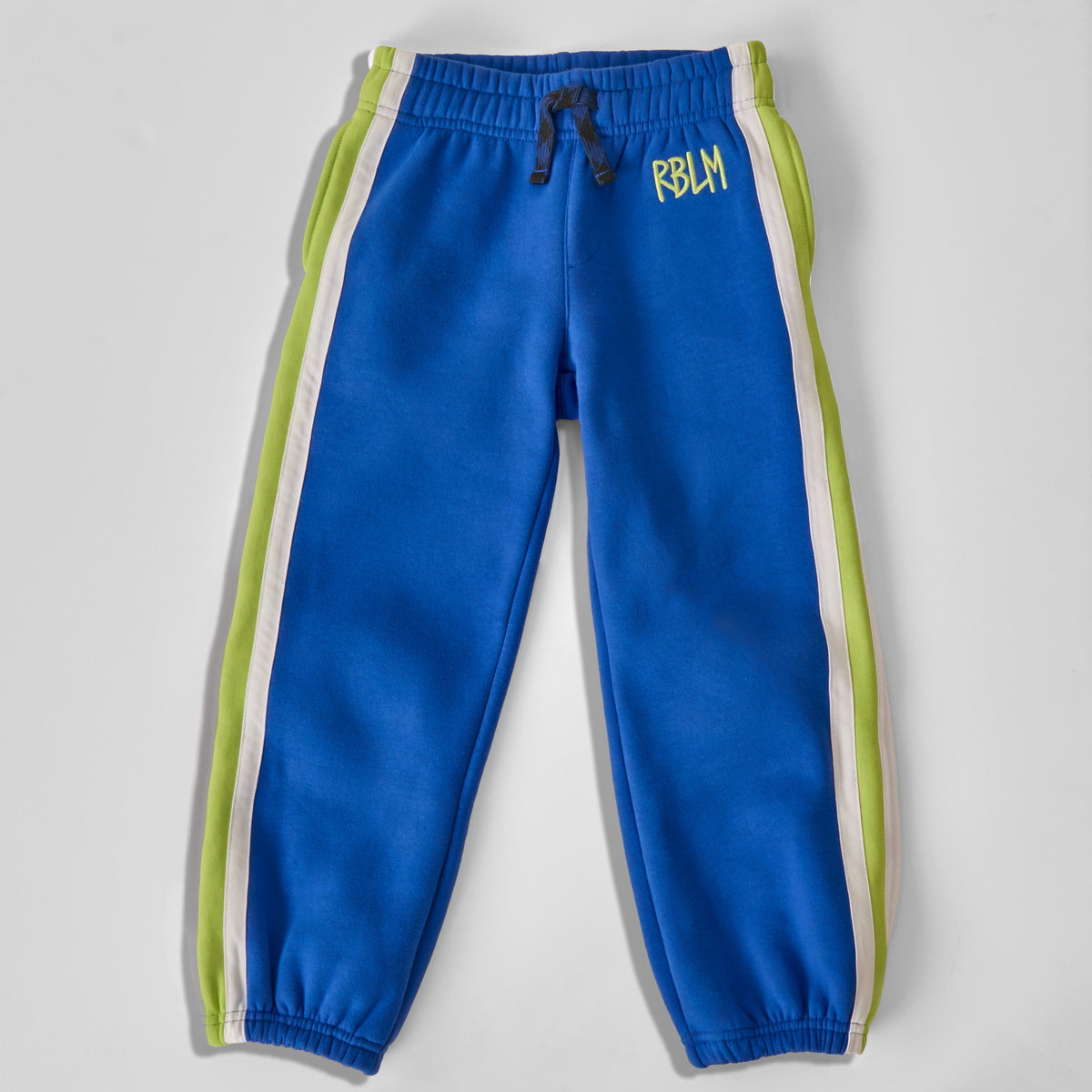 Sustainable and comfortable bright blue jogger sweatpants for kids with lime green and white side stripes, featuring a black and blue drawstring and 'RBLM' printed in green on the left hip, shown flat on a light gray background.