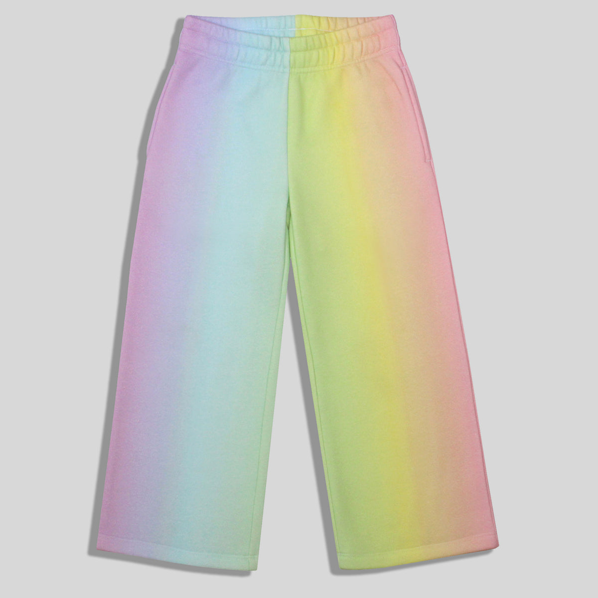 A sustainable, comfortable, and fun pair of wide-leg sweatpants for children with a pastel rainbow gradient print, shown against a neutral gray background.