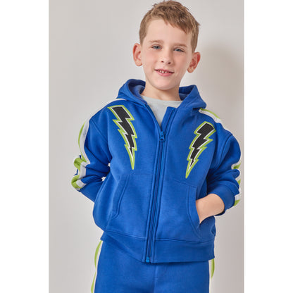A boy wearing a high-quality, eco-friendly blue zip-up hoodie with black and green lightning bolt graphics on the chest, paired with matching blue sweatpants.