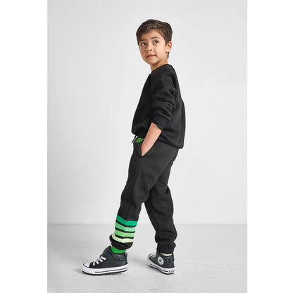 side view of boy wearing our eco-friendly green striped joggers