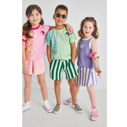 A boy and two girls wearing sustainable, hip, and colorful outfits.