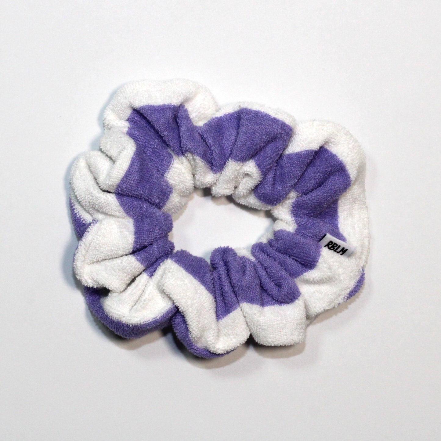 Purple and white scrunchie on a light gray background