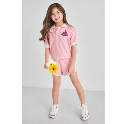 Girl wearing a sustainable, retro, pink Terry outfit with watermelon embroidery, holding daisies.
