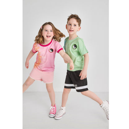 A boy and girl wearing sustainable tie-dye outfits for summer