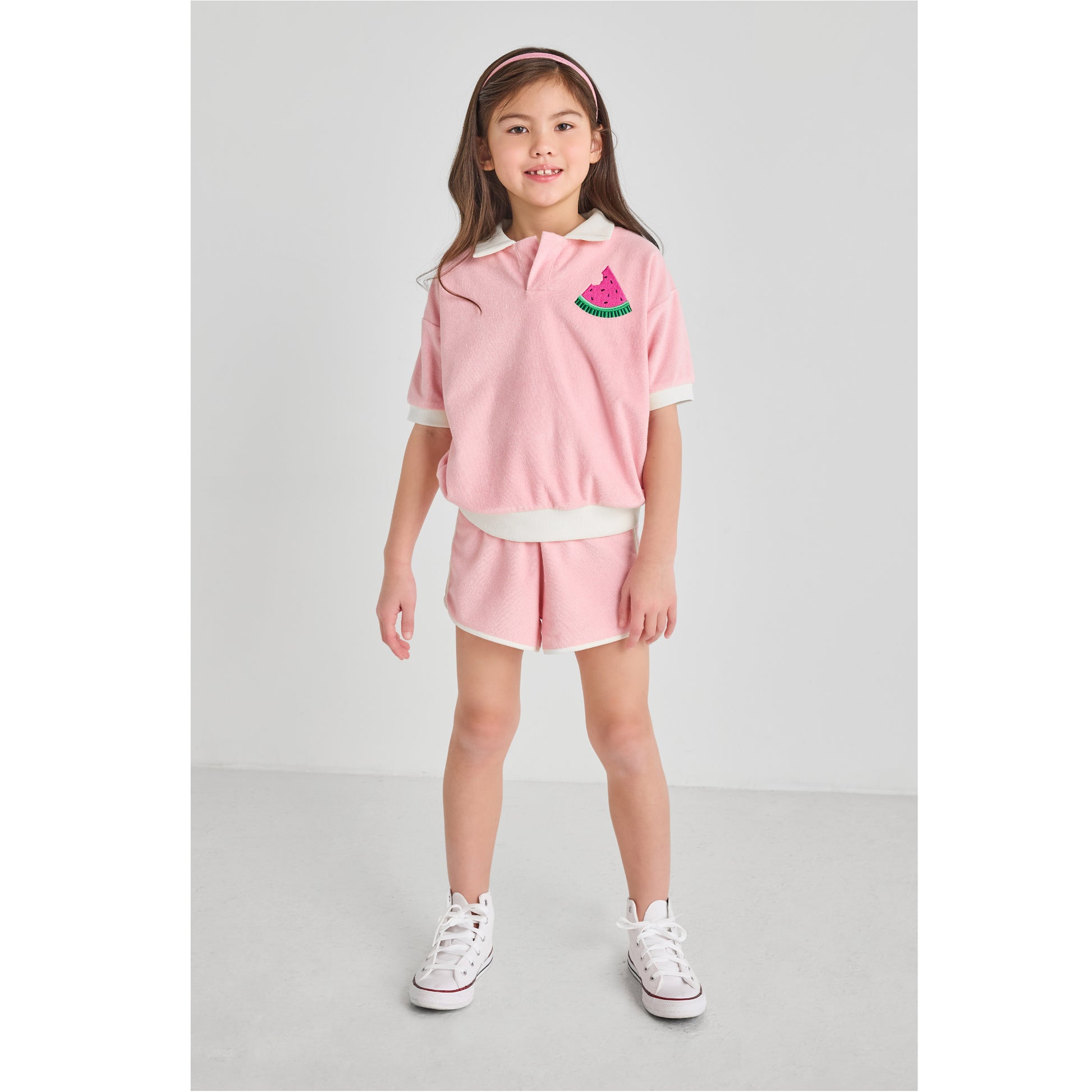 A girl wearing a sustainable, pink watermelon outfit.