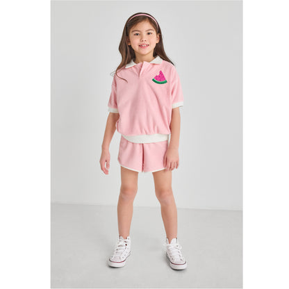 A girl wearing a sustainable, pink watermelon outfit.