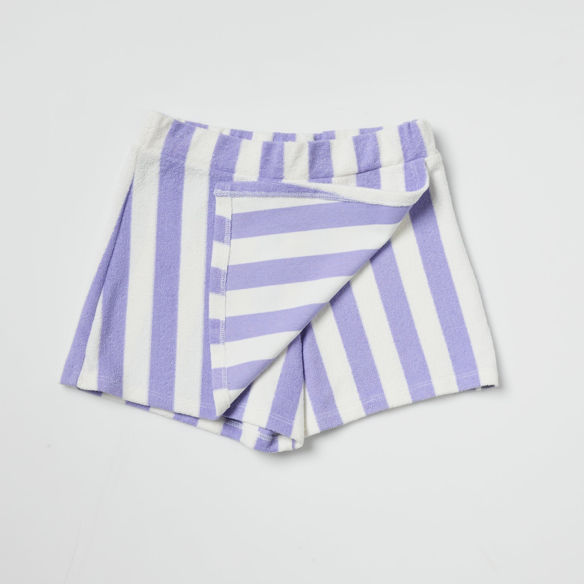 Sustainable kids folded purple and white striped skort on a light gray background