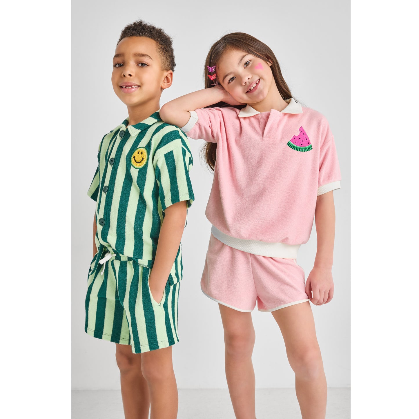 Two children wearing sustainable, colorful, hip summer outfits.
