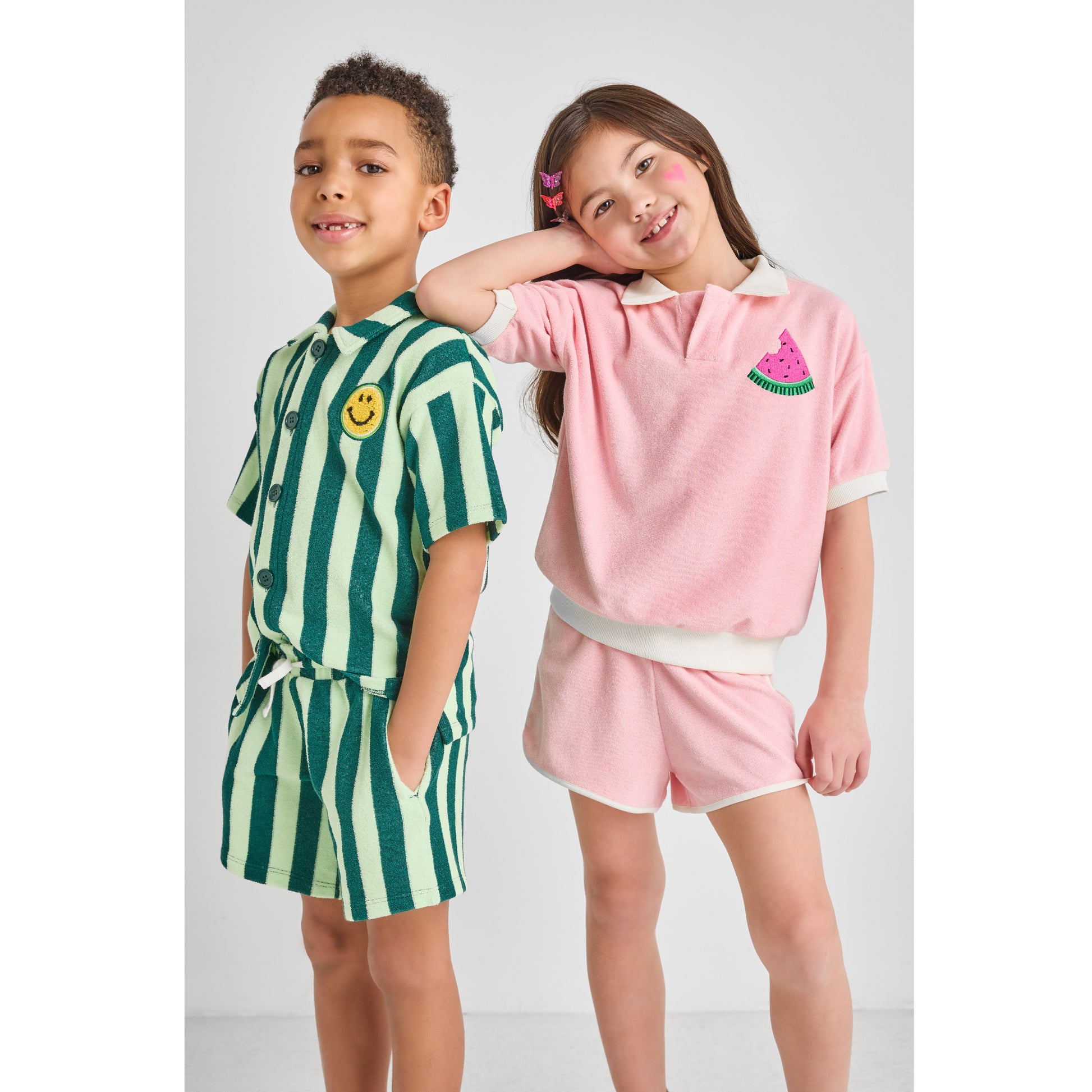 Two children wearing sustainable, colorful, hip summer outfits.