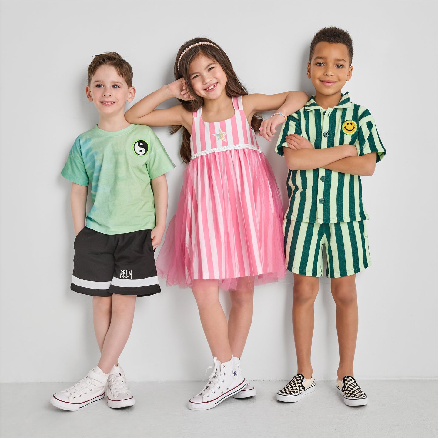 Three children wearing colorful, fun, and sustainable outfits