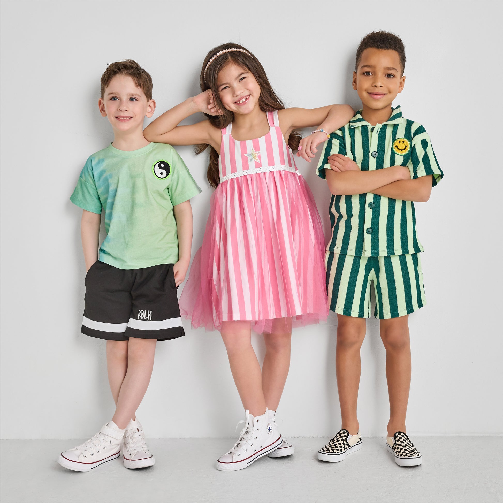 Three children wearing colorful, fun, and sustainable outfits
