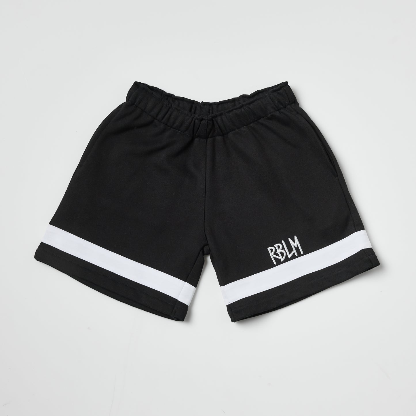 Eco-friendly kids black shorts with a white stripe on a white background