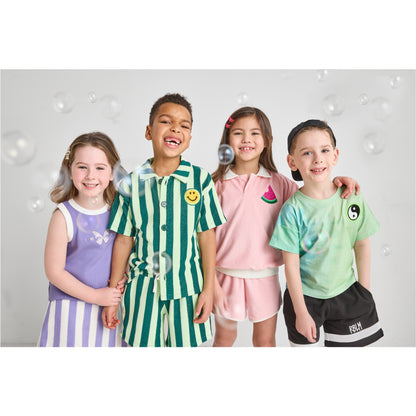 Children smiling and standing together wearing sustainable, fun clothing