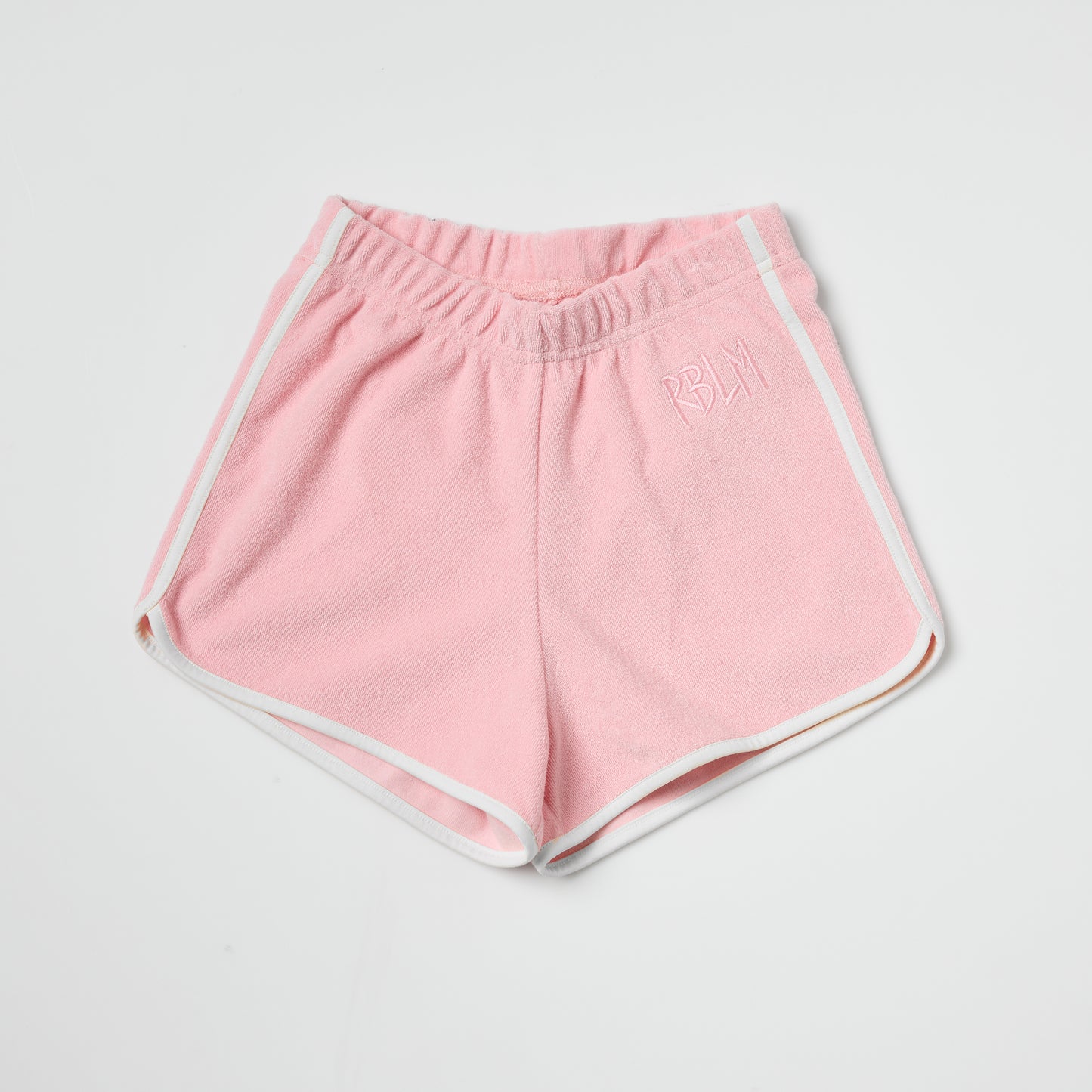 Eco-friendly kids pink shorts with white trim on a light gray background